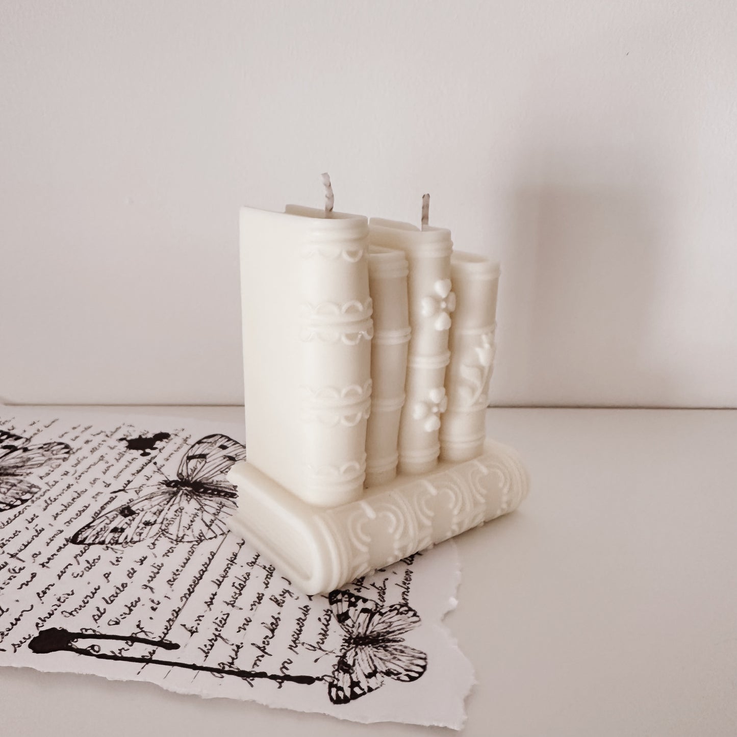 Vela artesanal em forma de pilha de livros, vista lateral. Feita à mão em Portugal. Tsuki Studio.